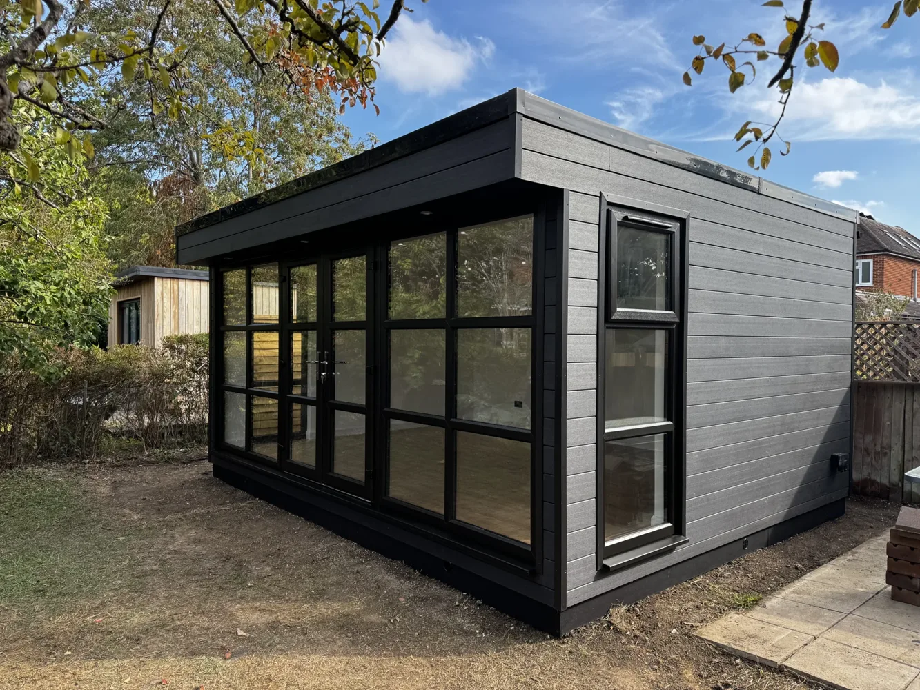 Completed garden office and gym in Ashtead, with charcoal cladding and black glazing
