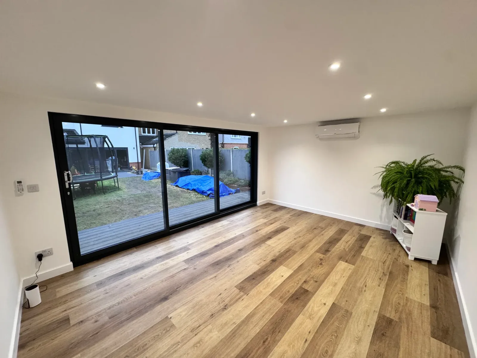 Finished garden-room interior with flooring, lighting and wide glazed doors