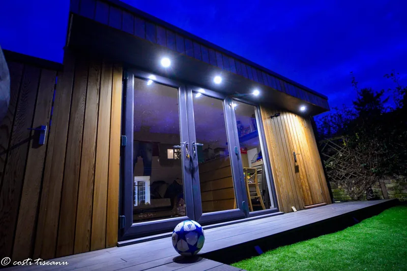 Completed garden room with exterior lighting at night