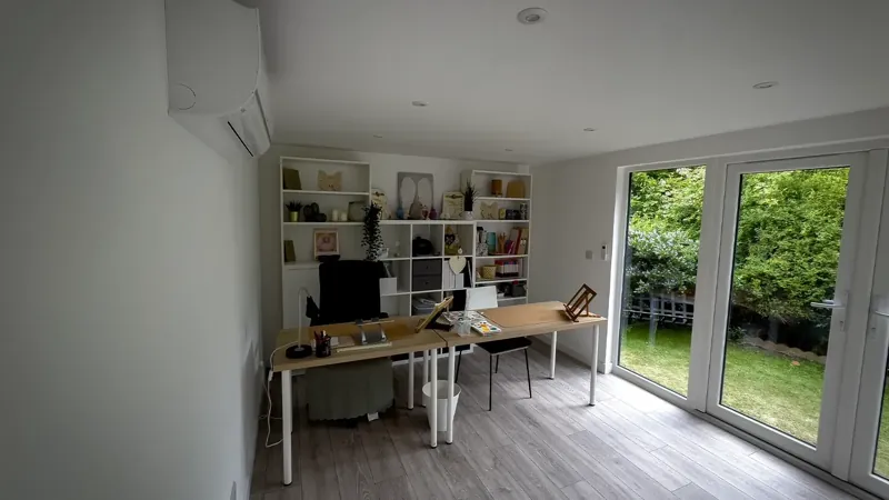 Garden office interior with desk and shelving