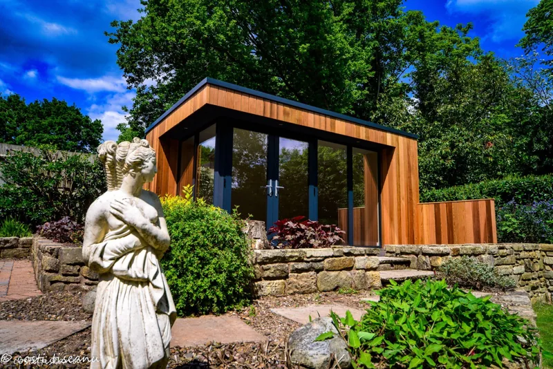 Timber-clad garden building with full-height glazing