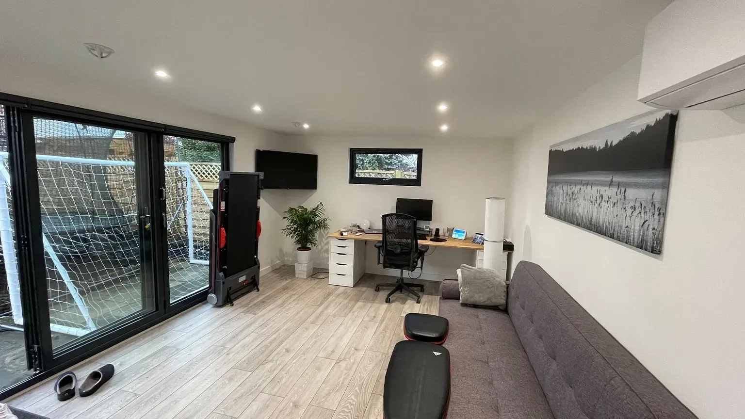 Interior of a TRJ garden office with a desk and glazed doors