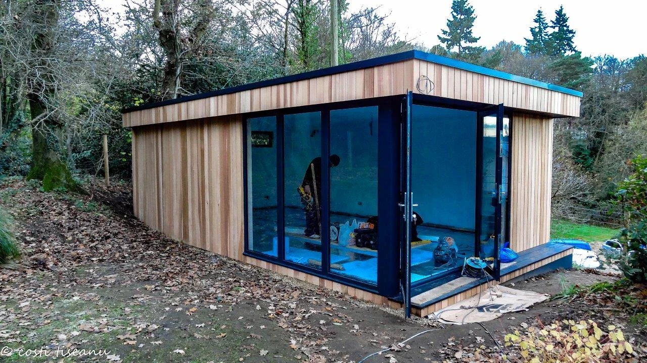 Cedar-clad Farnham games studio with corner glazing during installation