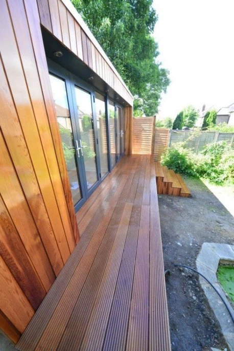 Hardwood decking beside the cedar-clad garden workshop