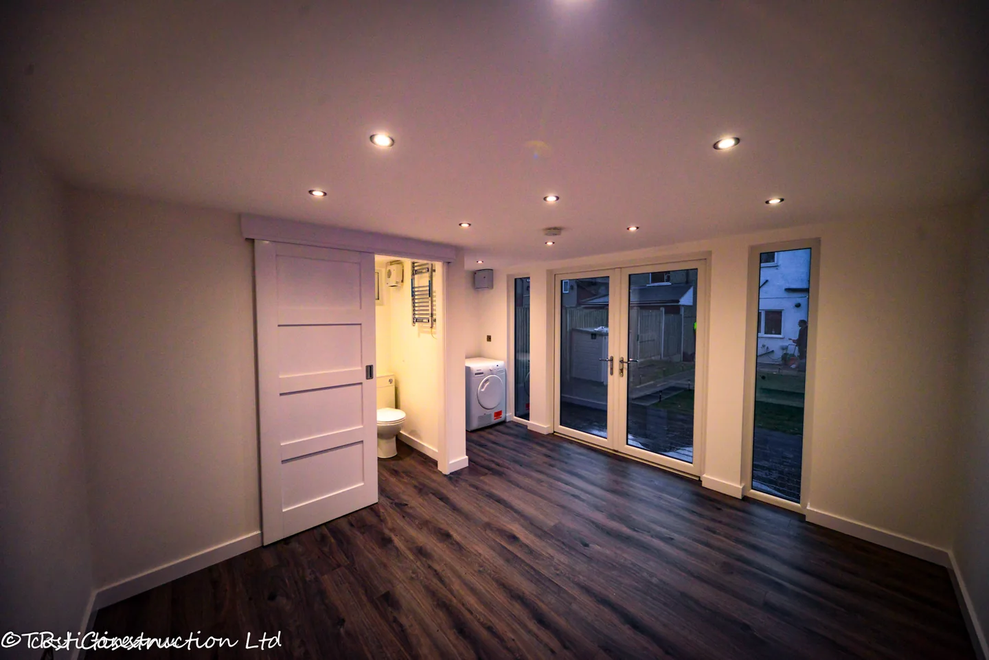 Main room with sliding ensuite door and full-height entrance glazing