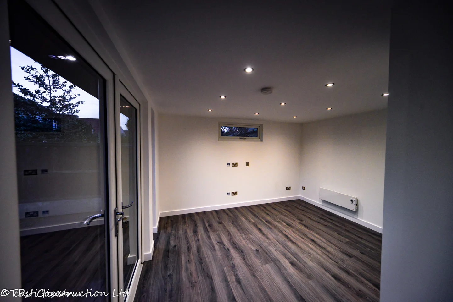 Flexible studio interior with laminate flooring and wall-mounted heater