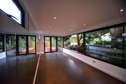 Natural light reflected through the mirrored exercise room