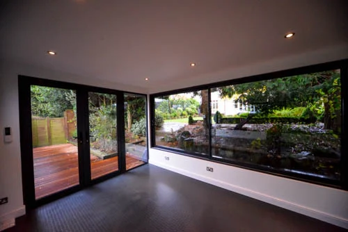 The dark-framed corner entrance and deck outside