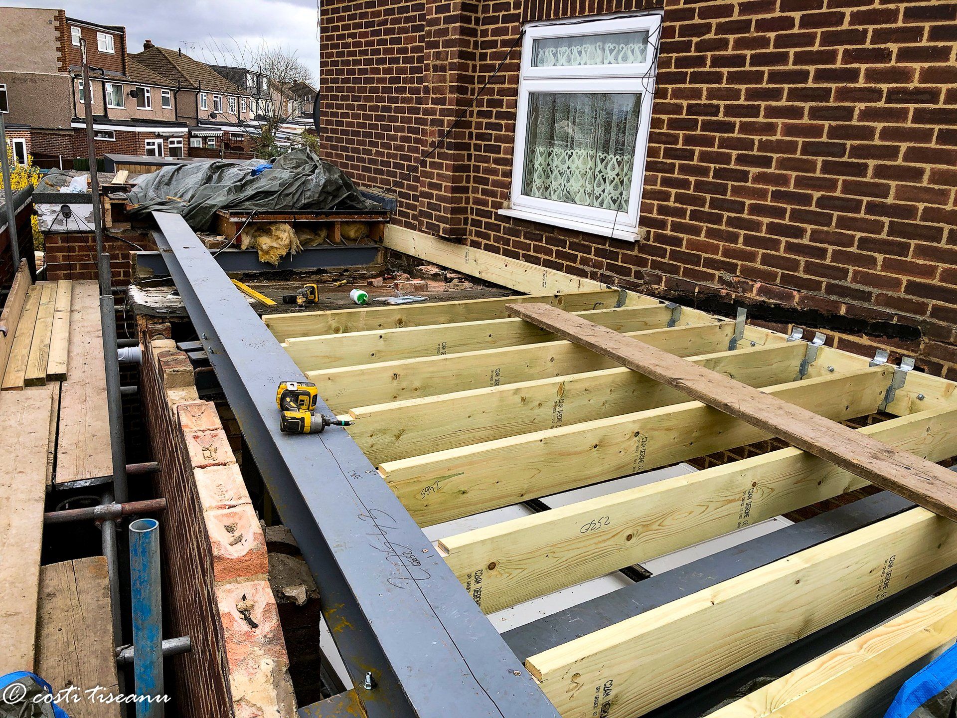 Timber roof structure under construction beside the house