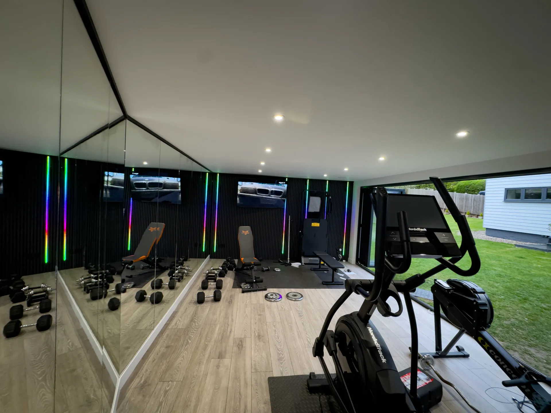 Garden gym cardio equipment beside wide glazing