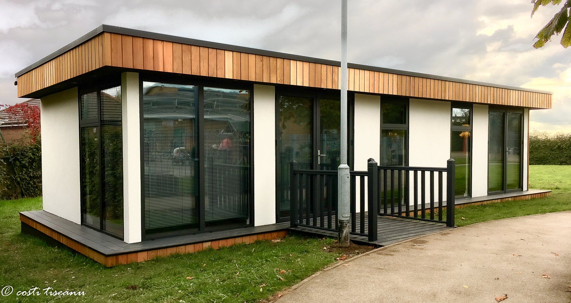 Rendered school building with corner glazing and gated access