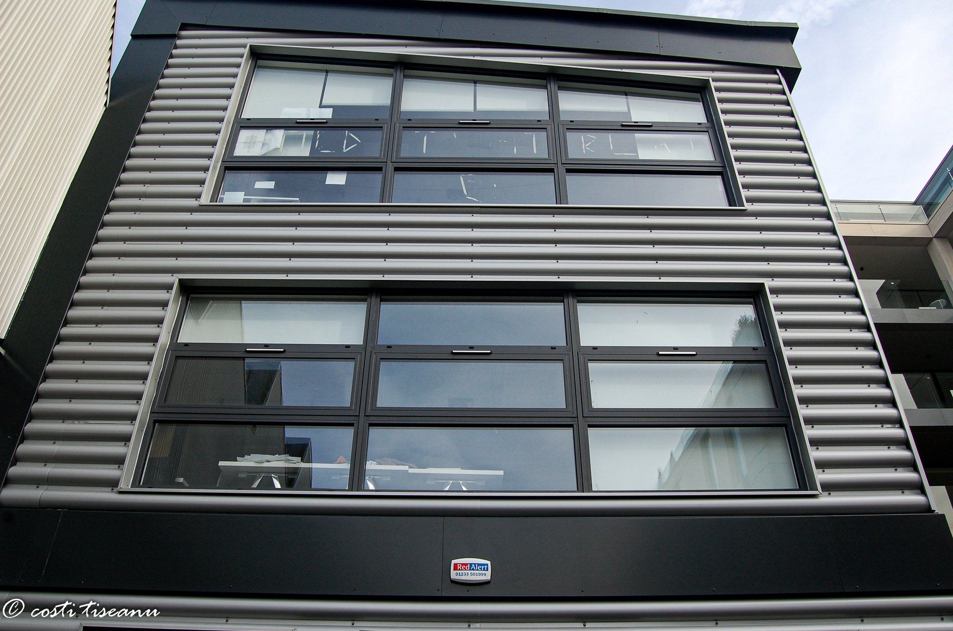 Upper windows and metal cladding on the commercial building